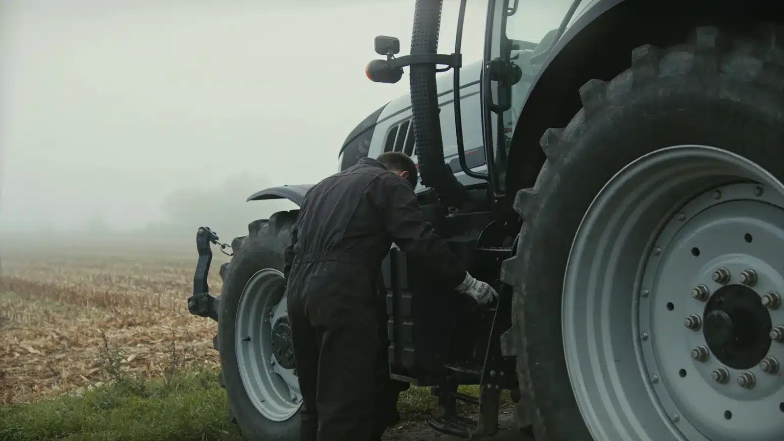 An operator inspects a tractor before starting work in the field